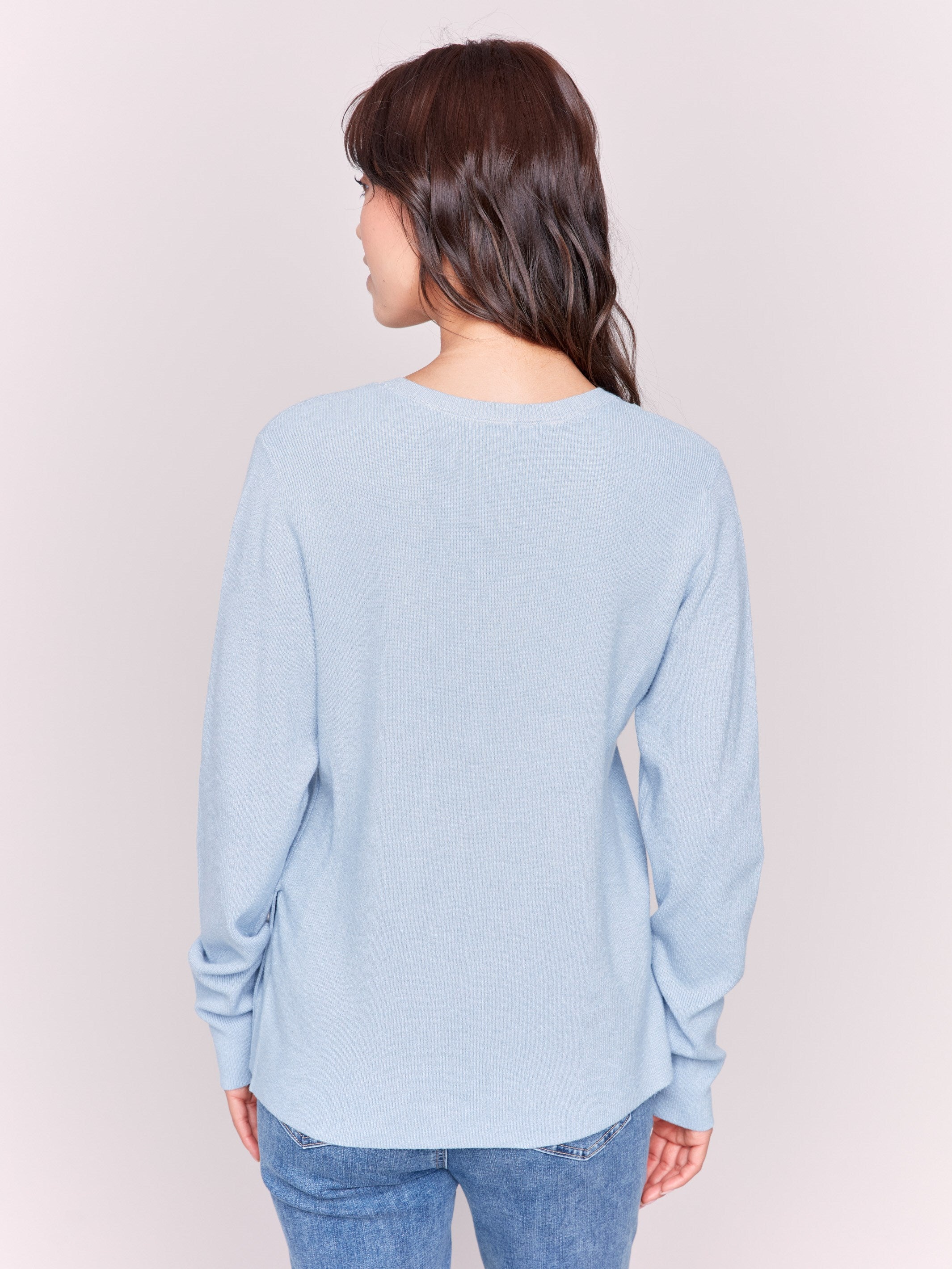 Frost-colored V-neck sweater with long sleeves featuring grommet details at the side placket by Charlie B.