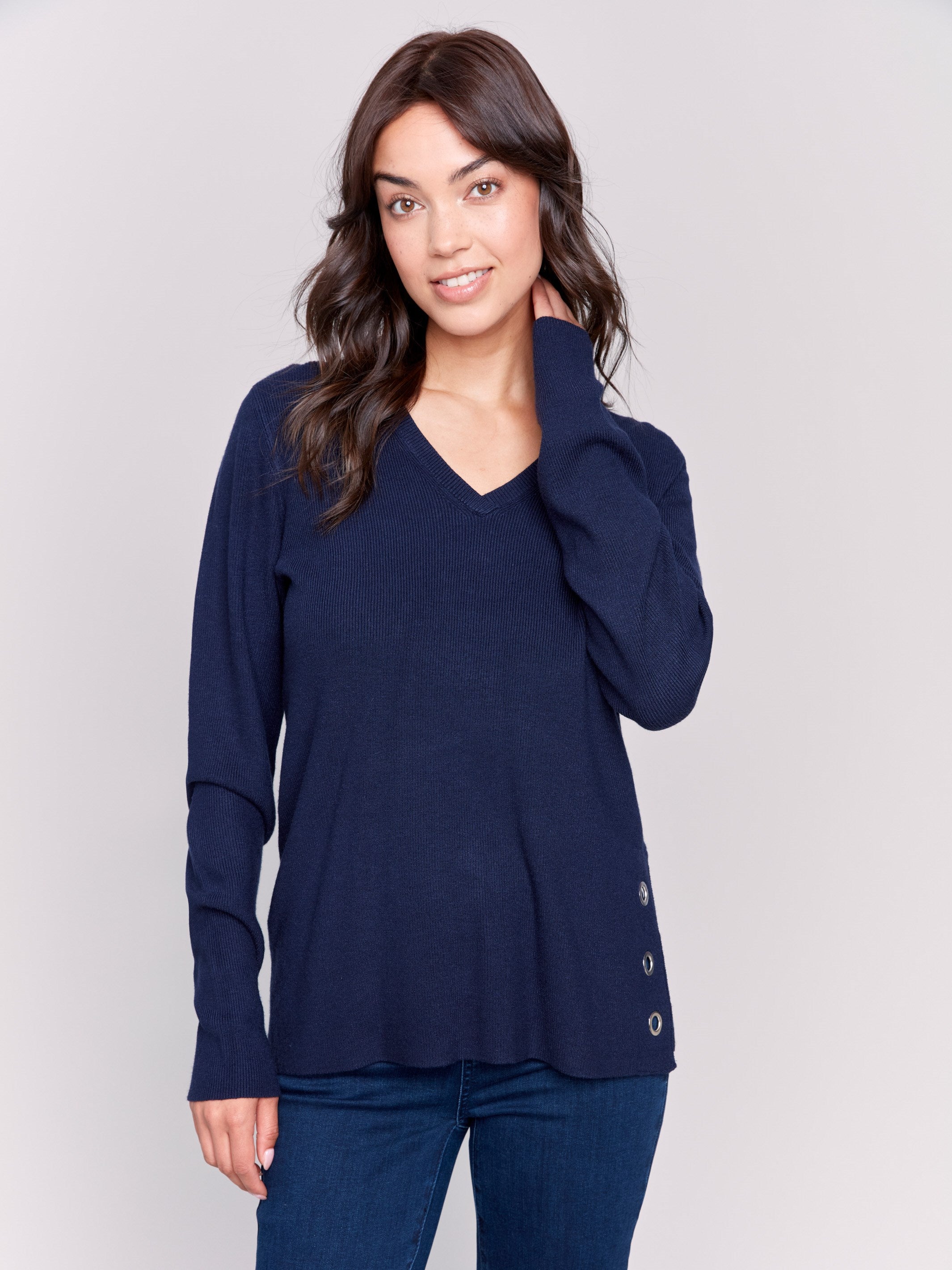 Navy-colored V-neck sweater with long sleeves featuring grommet details at the side placket by Charlie B.