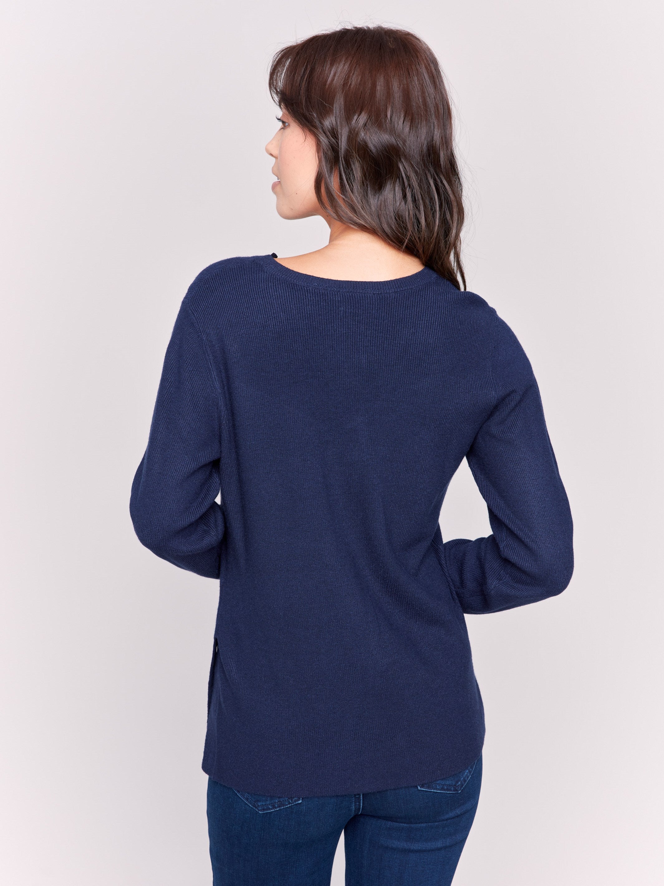 Navy-colored V-neck sweater with long sleeves featuring grommet details at the side placket by Charlie B.