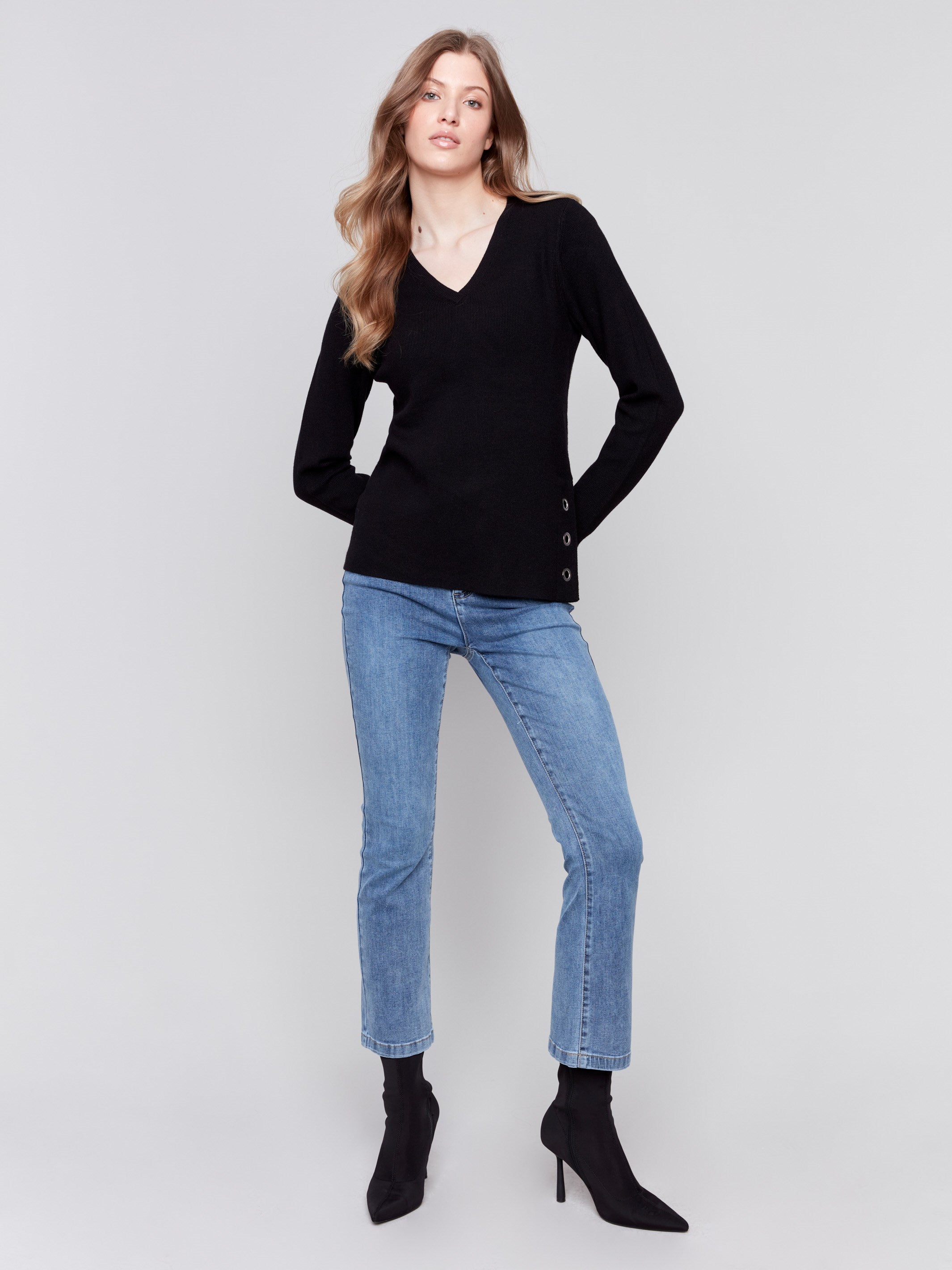 Black-colored V-neck sweater with long sleeves featuring grommet details at the side placket by Charlie B.